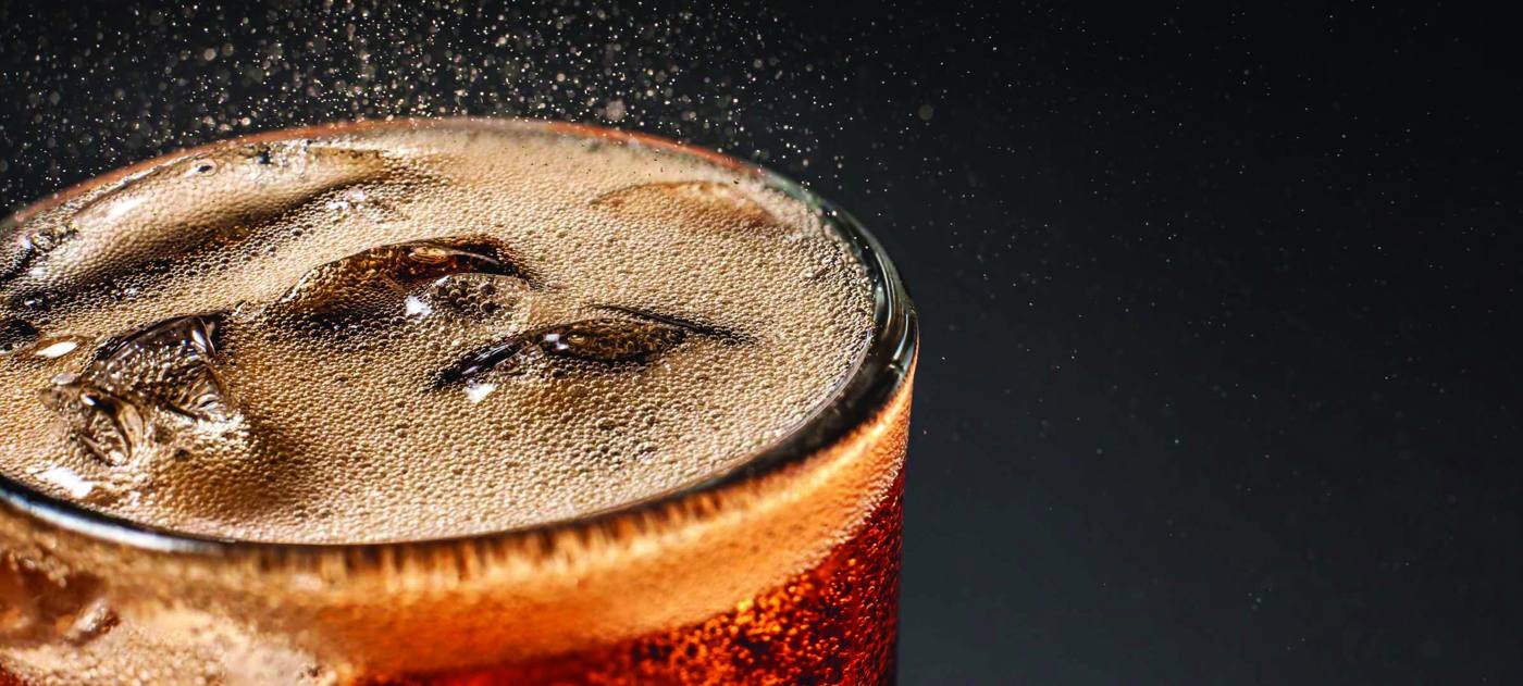 Close-up of a carbonated drink with ice and fine bubbles