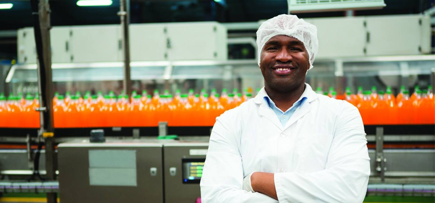 Maticline technician in front of a running juice bottling line